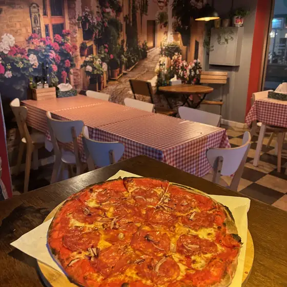 Pizza z salami na obrusie w kratkę